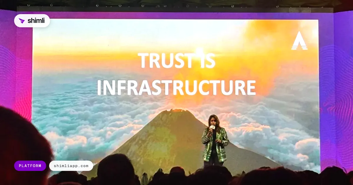 Large screen reading Trust is infrastructure over a volcano, with a speaker on stage at Volcano Summit 2026